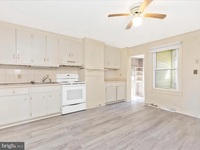a kitchen with a refrigerator and white cabinets