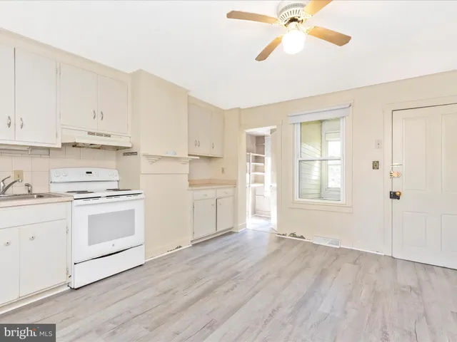 a view of kitchen with white cabinets and white appliances