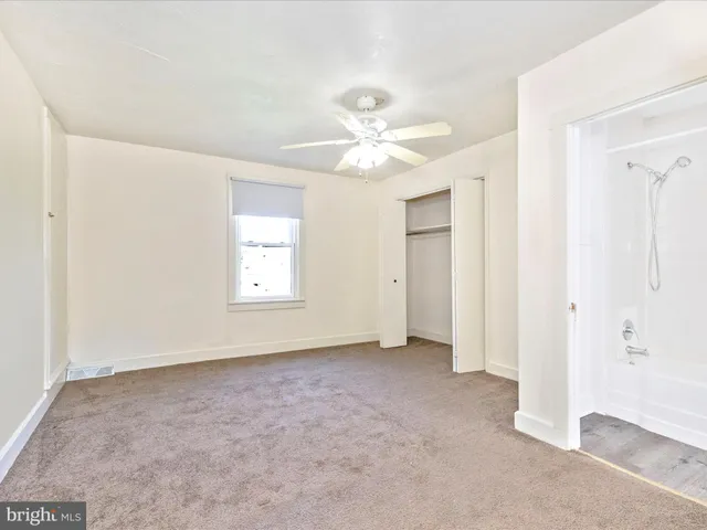 a bathroom with a granite countertop toilet a sink and a window