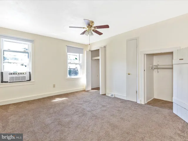 an empty room with a window and a fan