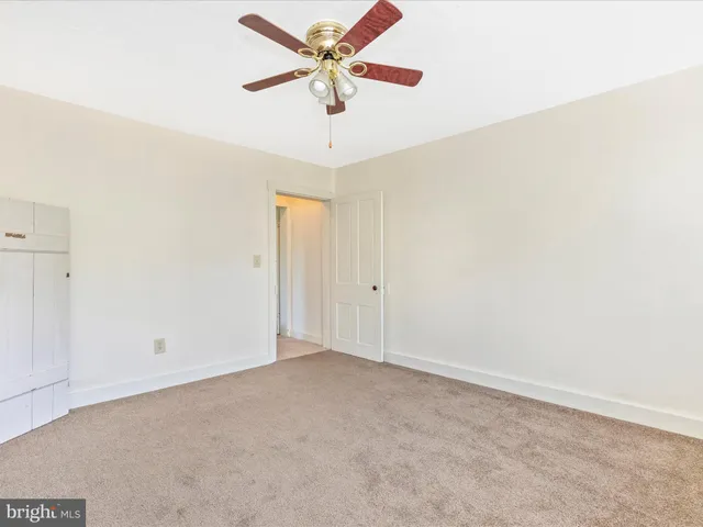 an empty room with closet and fan