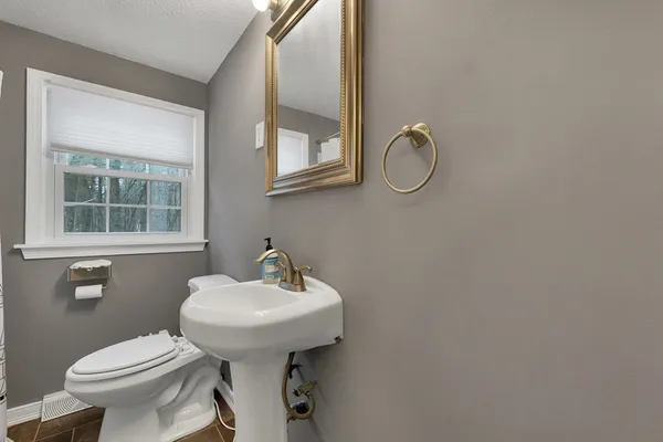 a bathroom with a toilet sink and mirror