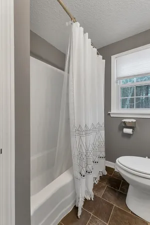 a bathroom with a toilet and a shower