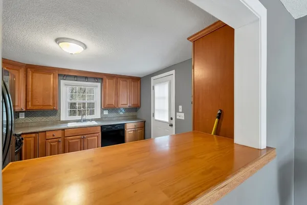 a large kitchen with stainless steel appliances granite countertop a sink and cabinets