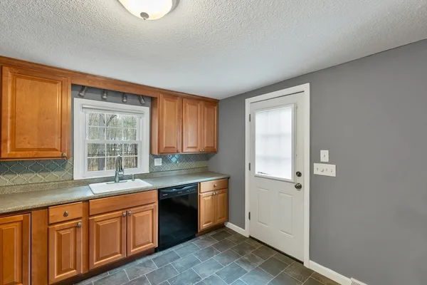 a kitchen with stainless steel appliances granite countertop a sink a stove and a refrigerator
