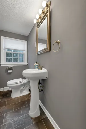 a bathroom with a sink toilet and a mirror