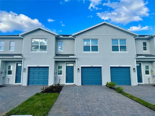 a front view of a house with a garden and yard