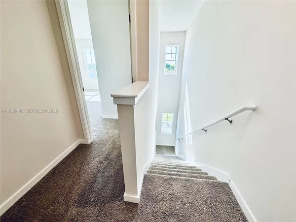 a view of entryway and hall with wooden floor