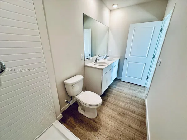a bathroom with a sink a toilet a mirror and vanity