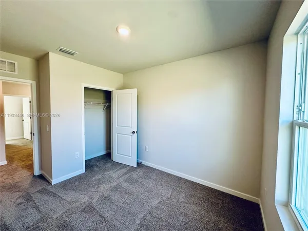 an empty room with windows and closet