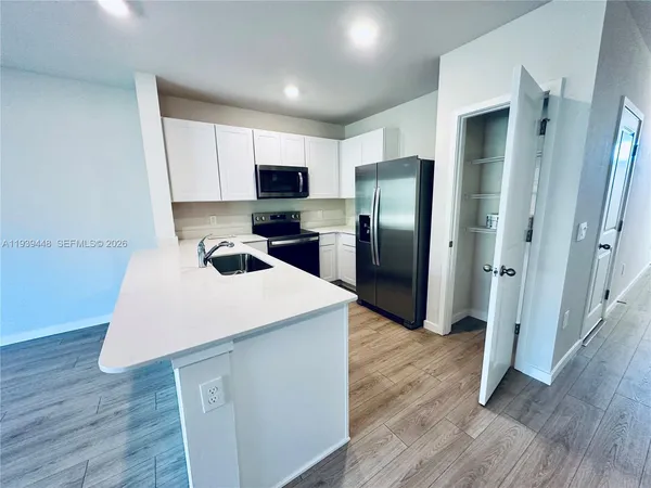 a kitchen with stainless steel appliances a refrigerator stove microwave and cabinets