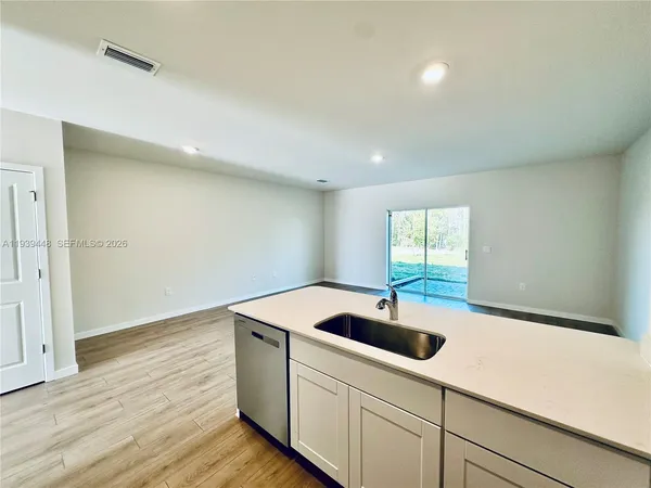 a kitchen with a sink cabinets and wooden floor