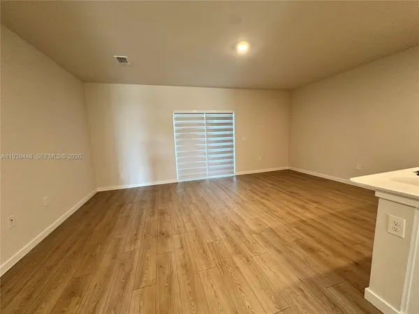 a view of empty room with wooden floor