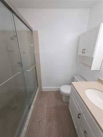 a bathroom with a granite countertop sink toilet and shower