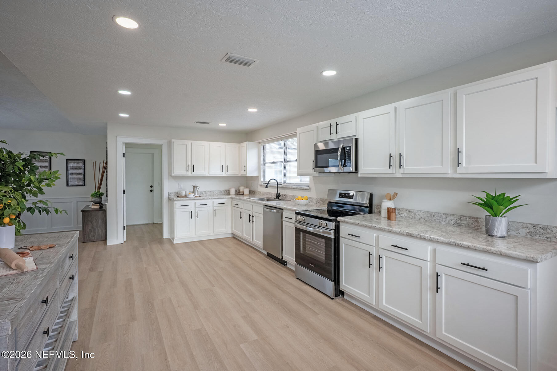 2451 Ridgecrest Avenue Orange Park, FL 32065 - Photo 11 of 57 a kitchen with granite countertop white cabinets and stainless steel appliances