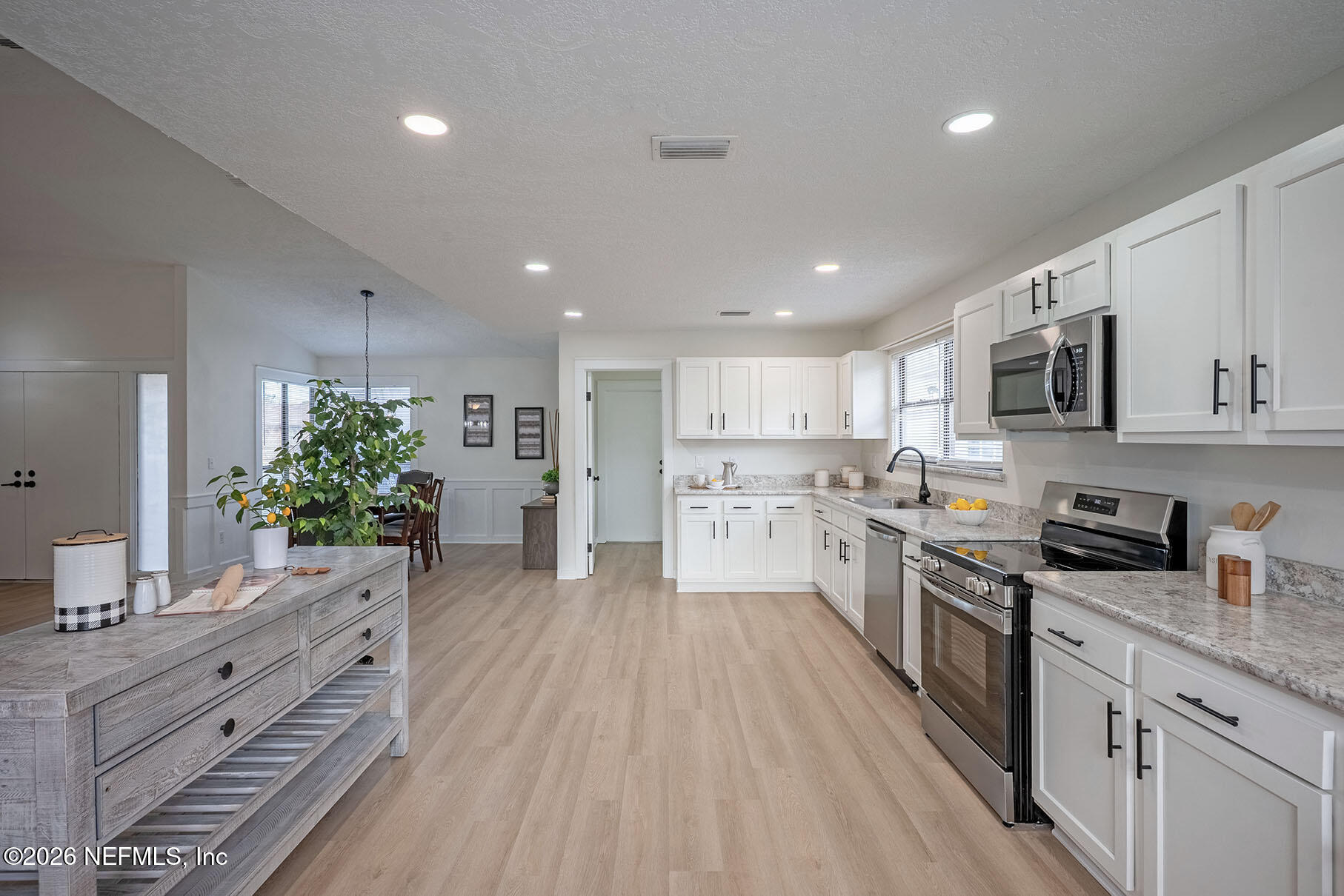 2451 Ridgecrest Avenue Orange Park, FL 32065 - Photo 3 of 57 a kitchen with stainless steel appliances kitchen island granite countertop a stove a sink dishwasher a refrigerator and white cabinets with wooden floor