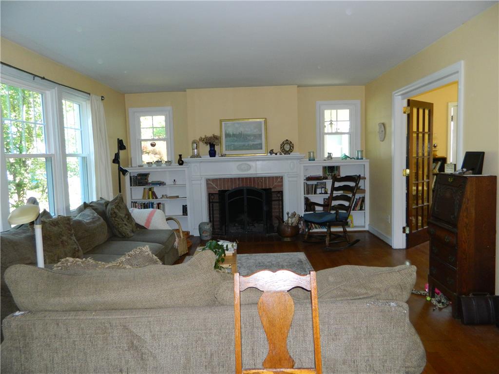 2130 Huntington Street Bethlehem, PA 18017 - Photo 5 of 23 A well-lit living space features a traditional brick fireplace flanked by built-in shelving.