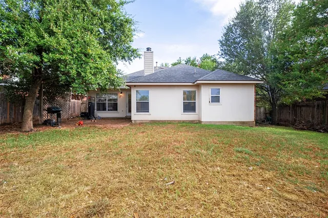 a backyard of a house with yard and tree