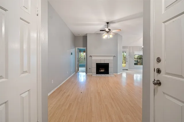 a view of empty room with wooden floor and fan