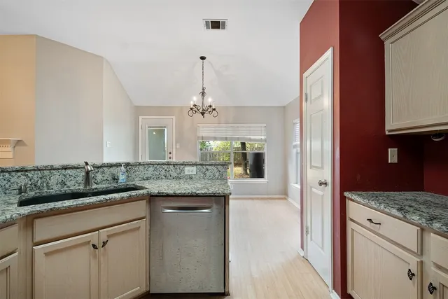 a kitchen with granite countertop kitchen island white cabinets and stainless steel appliances
