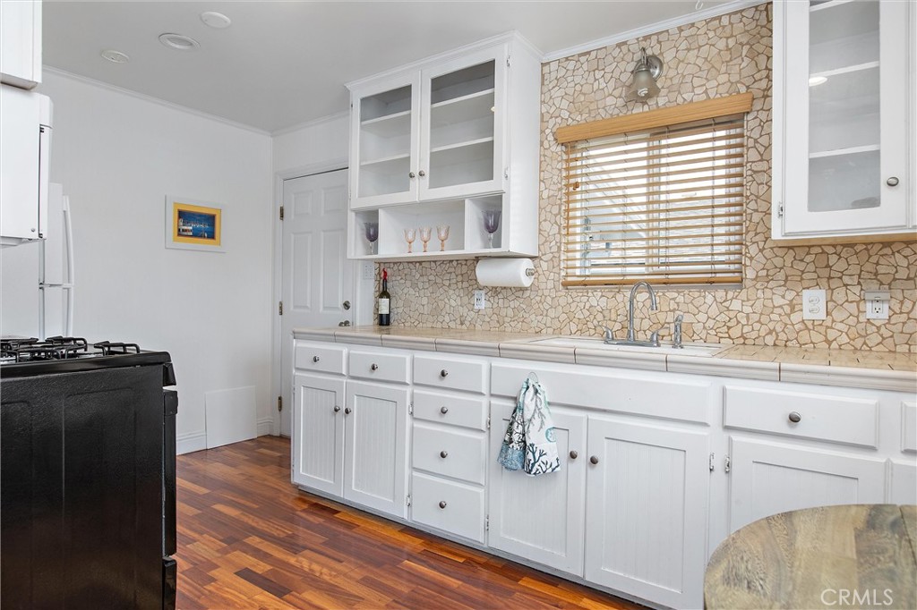 440 Java Street Morro Bay, CA 93442 - Photo 11 of 22 a kitchen with granite countertop white cabinets and black appliances