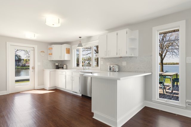 35013 North James Ingleside, IL 60041 - Photo 13 of 46 a kitchen with stainless steel appliances granite countertop a refrigerator a sink dishwasher a stove with wooden floor and cabinets