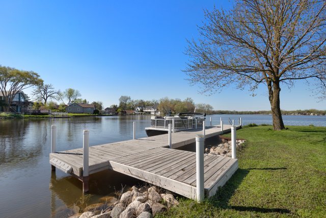 35013 North James Ingleside, IL 60041 - Photo 39 of 46 a view of a lake with couches chairs and wooden fence