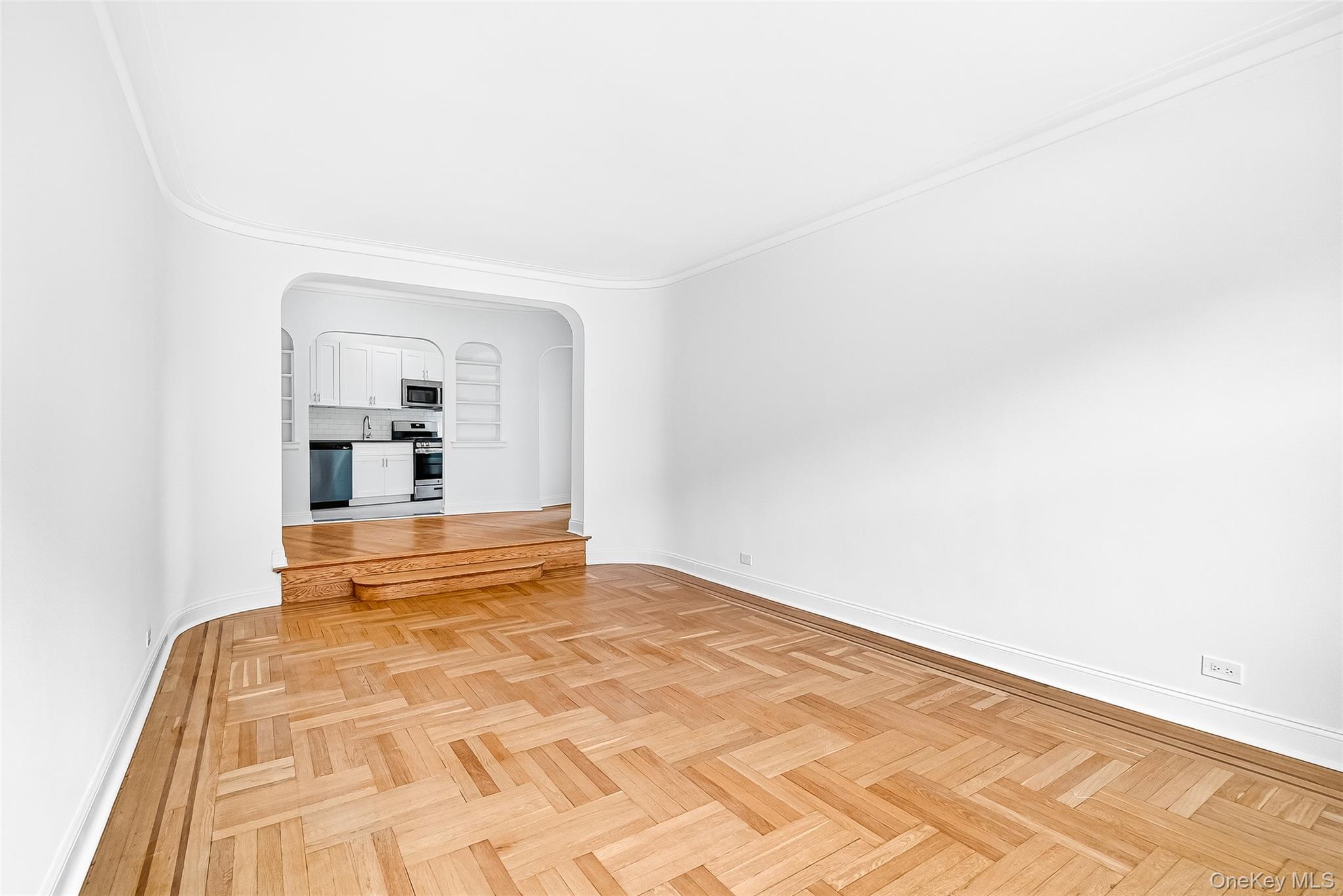 190 East Mosholu Parkway South, Unit 3C Bronx, NY 10458 - Photo 26 of 50 Unfurnished living room featuring arched walkways and ornamental molding