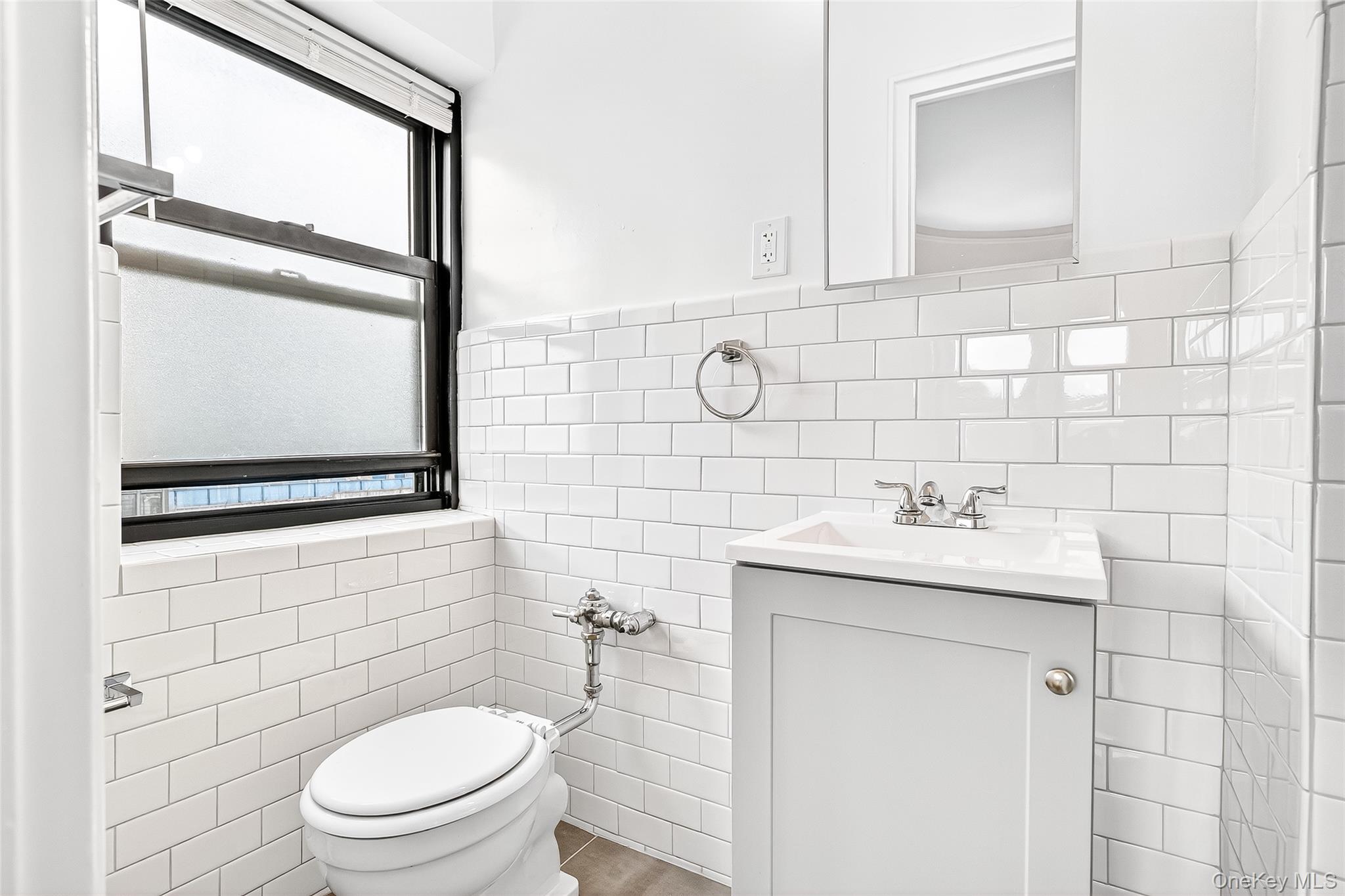 190 East Mosholu Parkway South, Unit 3C Bronx, NY 10458 - Photo 37 of 50 Bathroom featuring tile walls, vanity, and wainscoting