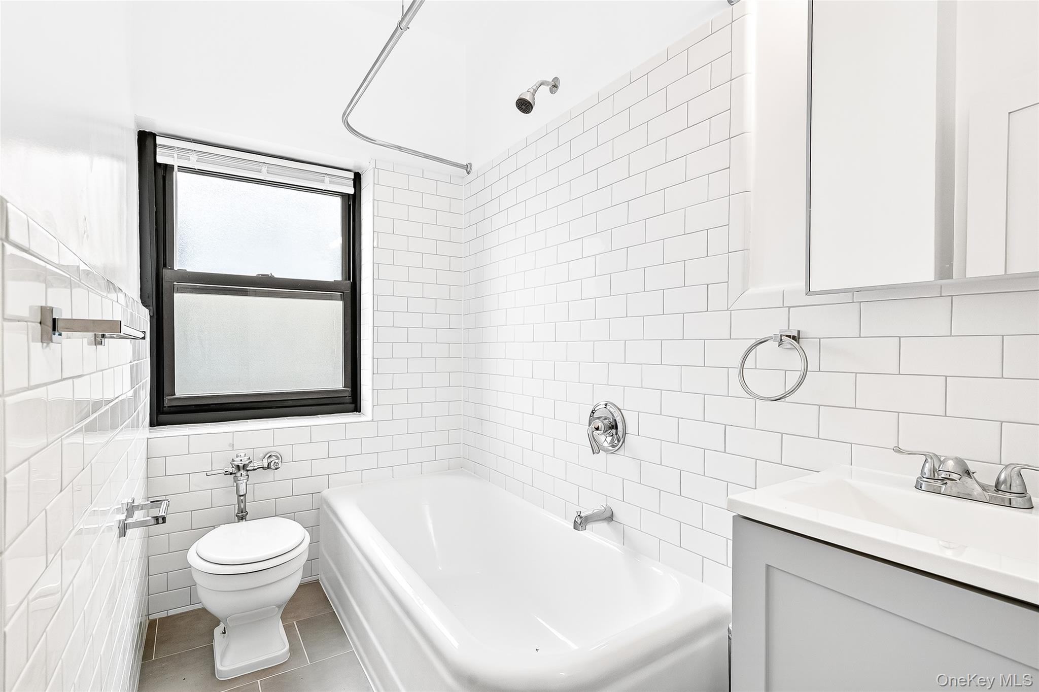190 East Mosholu Parkway South, Unit 3C Bronx, NY 10458 - Photo 45 of 50 Full bathroom featuring washtub / shower combination, tile walls, vanity, and tile patterned flooring