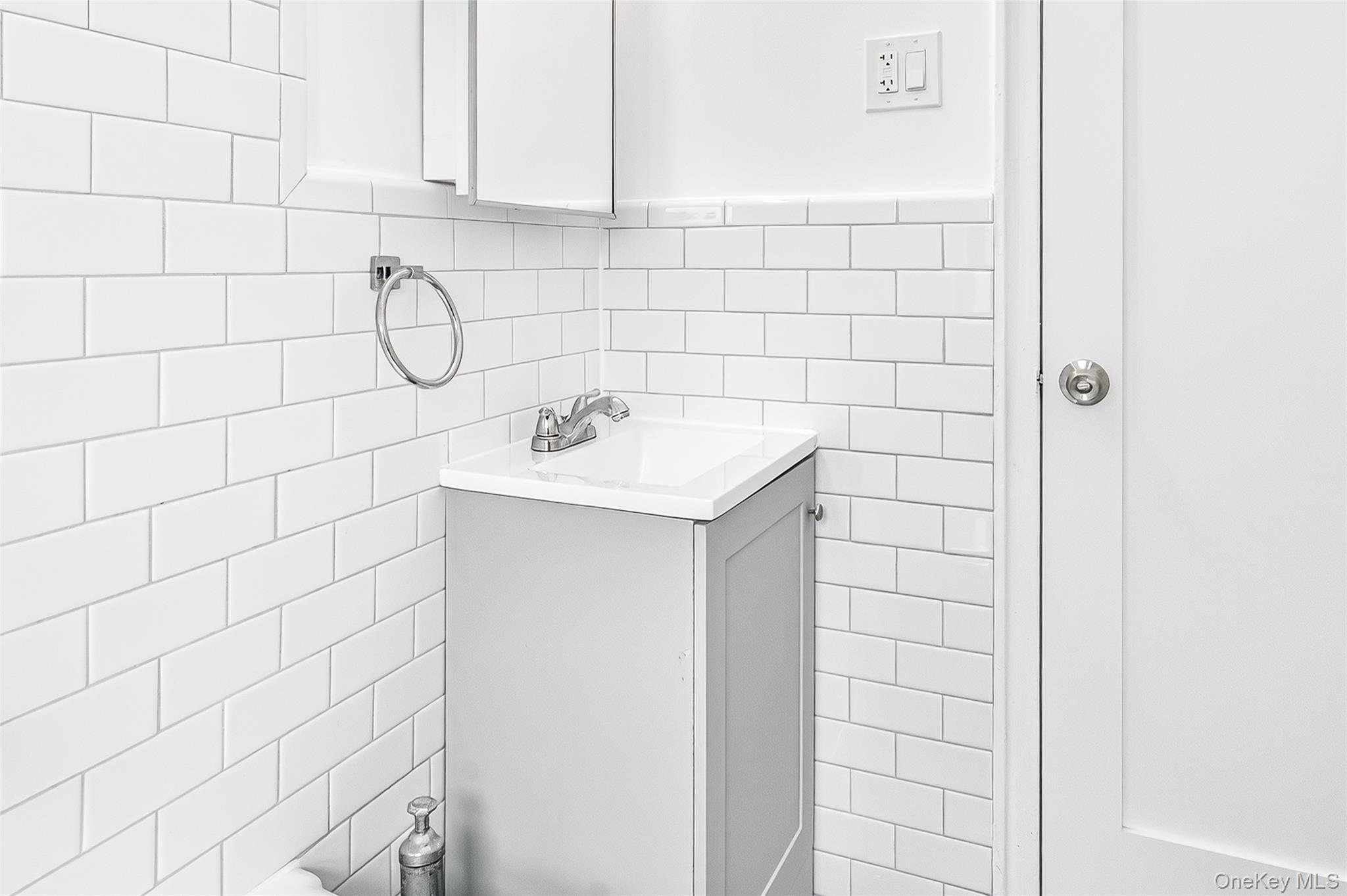 190 East Mosholu Parkway South, Unit 3C Bronx, NY 10458 - Photo 47 of 50 Half bath with vanity and tile walls