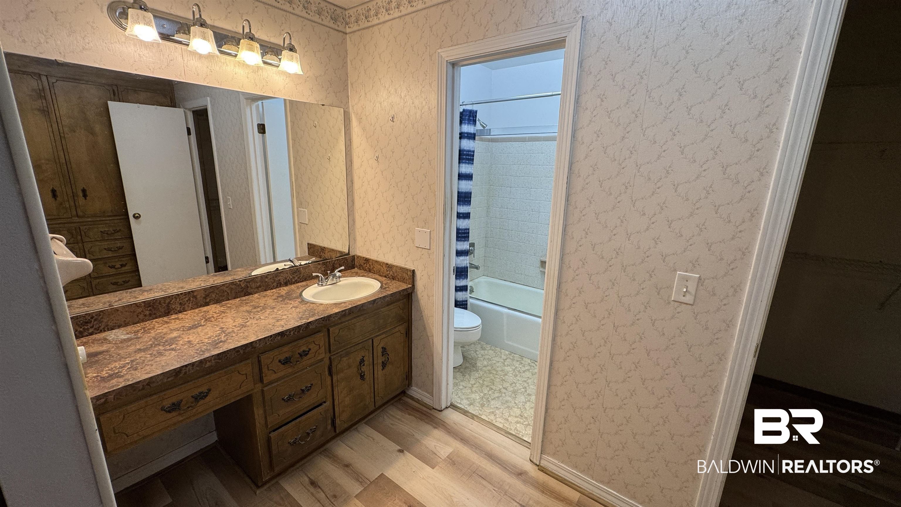 33370 Highway 98 Lillian, AL 36549 - Photo 31 of 58 Bathroom vanity featuring a single sink, an integrated countertop, and a large wall mirror