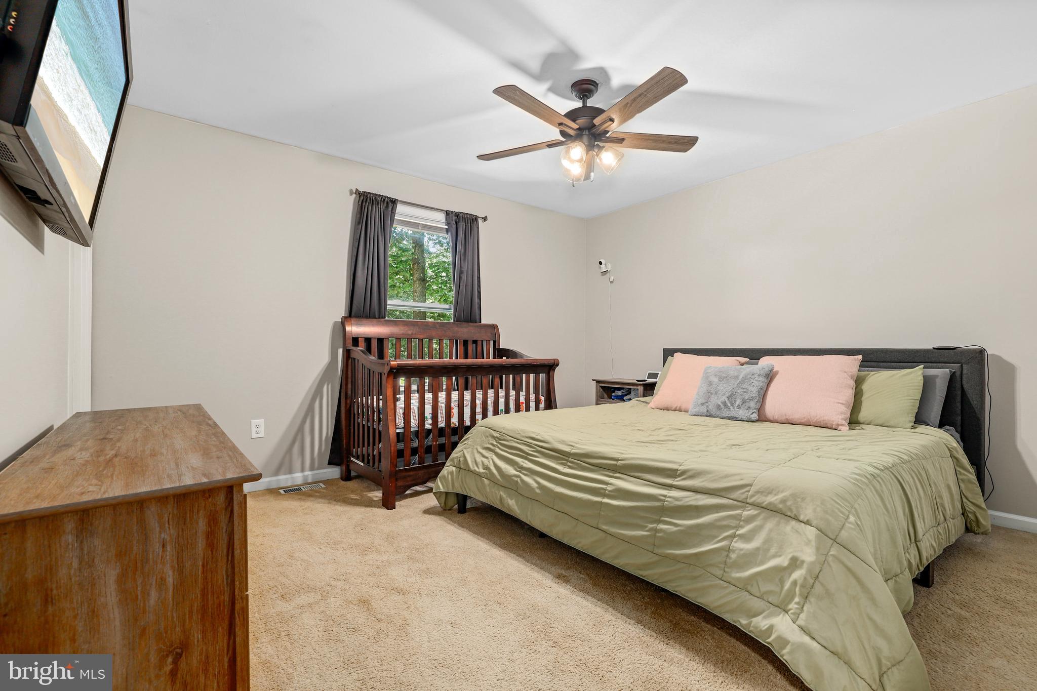 956 Wilson Road Huntingtown, MD 20639 - Photo 20 of 42 a bedroom with a bed a chandelier and a window