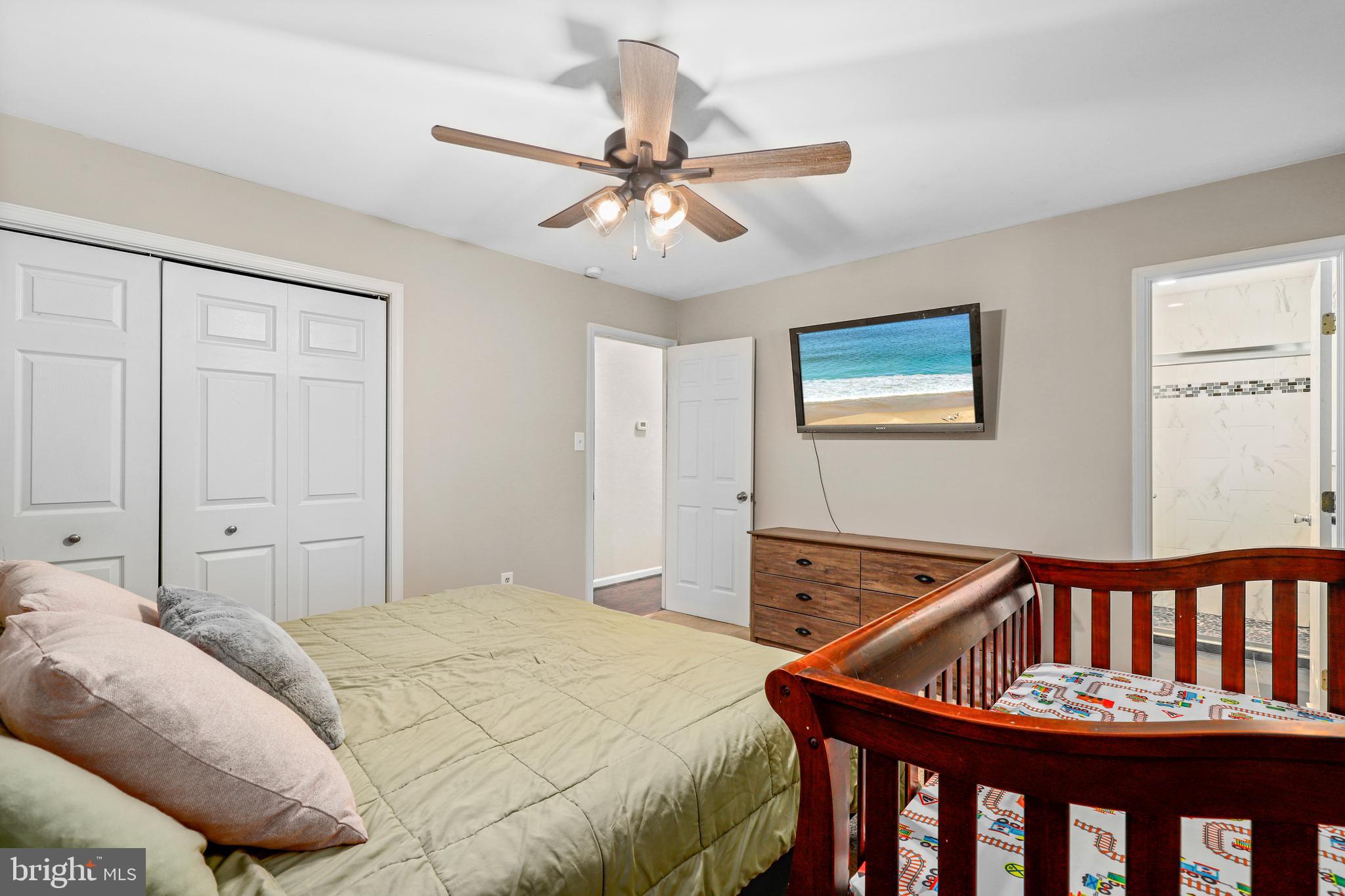 956 Wilson Road Huntingtown, MD 20639 - Photo 22 of 42 a bedroom with a bed and a chandelier