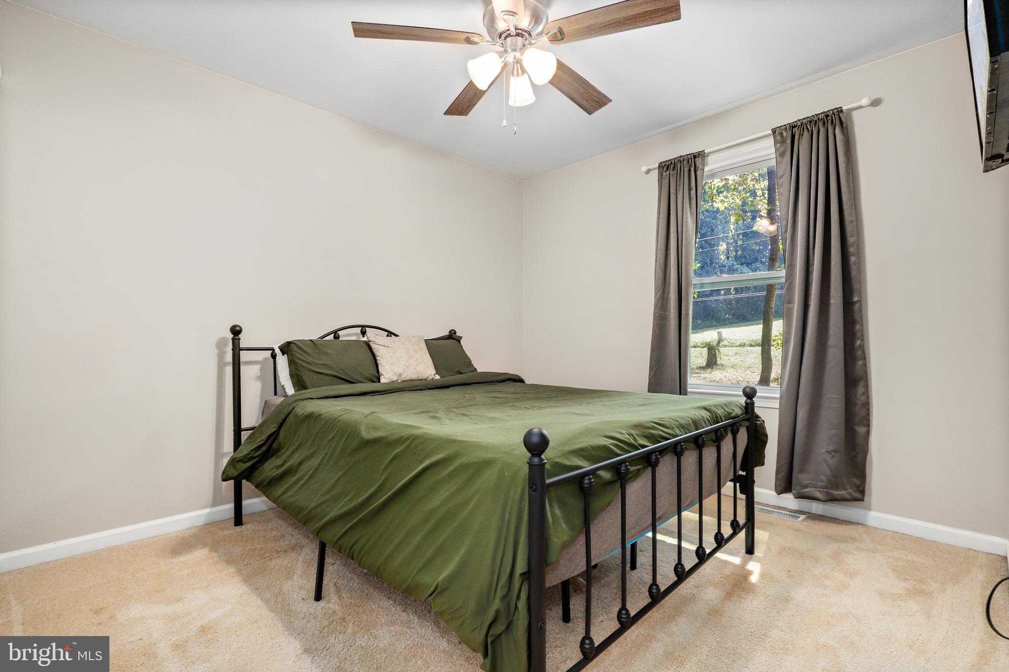 956 Wilson Road Huntingtown, MD 20639 - Photo 25 of 42 a bedroom with a bed and a chandelier
