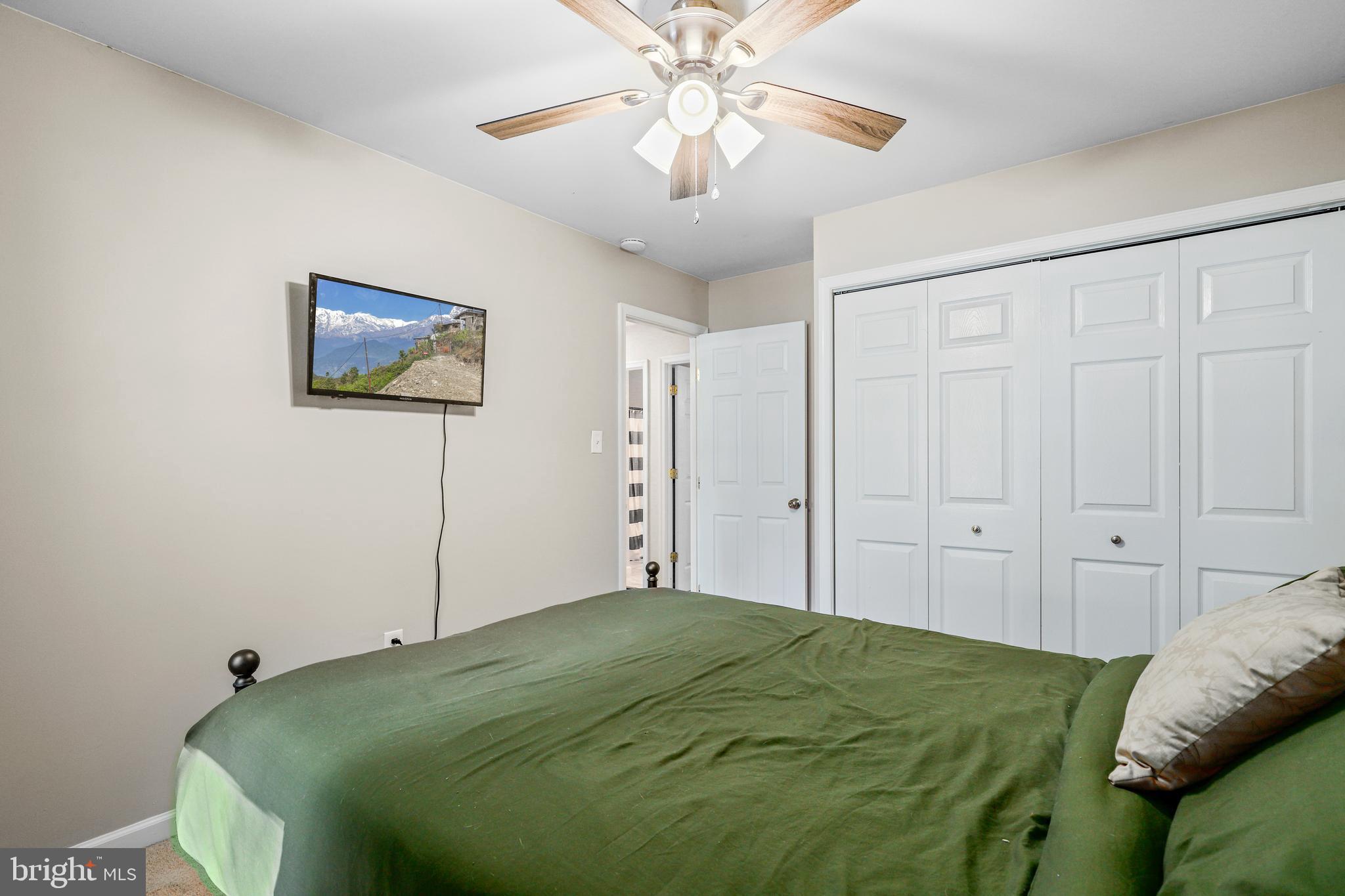 956 Wilson Road Huntingtown, MD 20639 - Photo 26 of 42 a bedroom with a bed and a chandelier