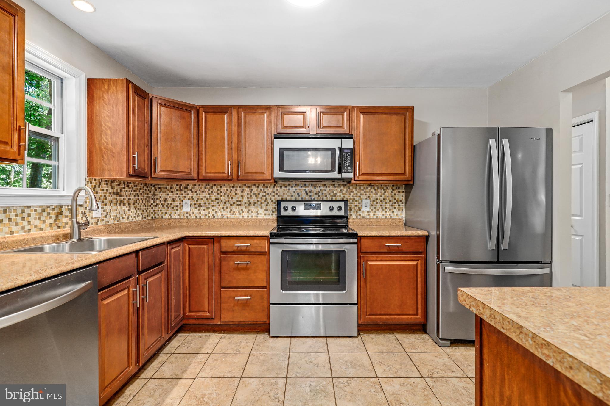 956 Wilson Road Huntingtown, MD 20639 - Photo 6 of 42 a kitchen with stainless steel appliances granite countertop a stove sink and cabinets