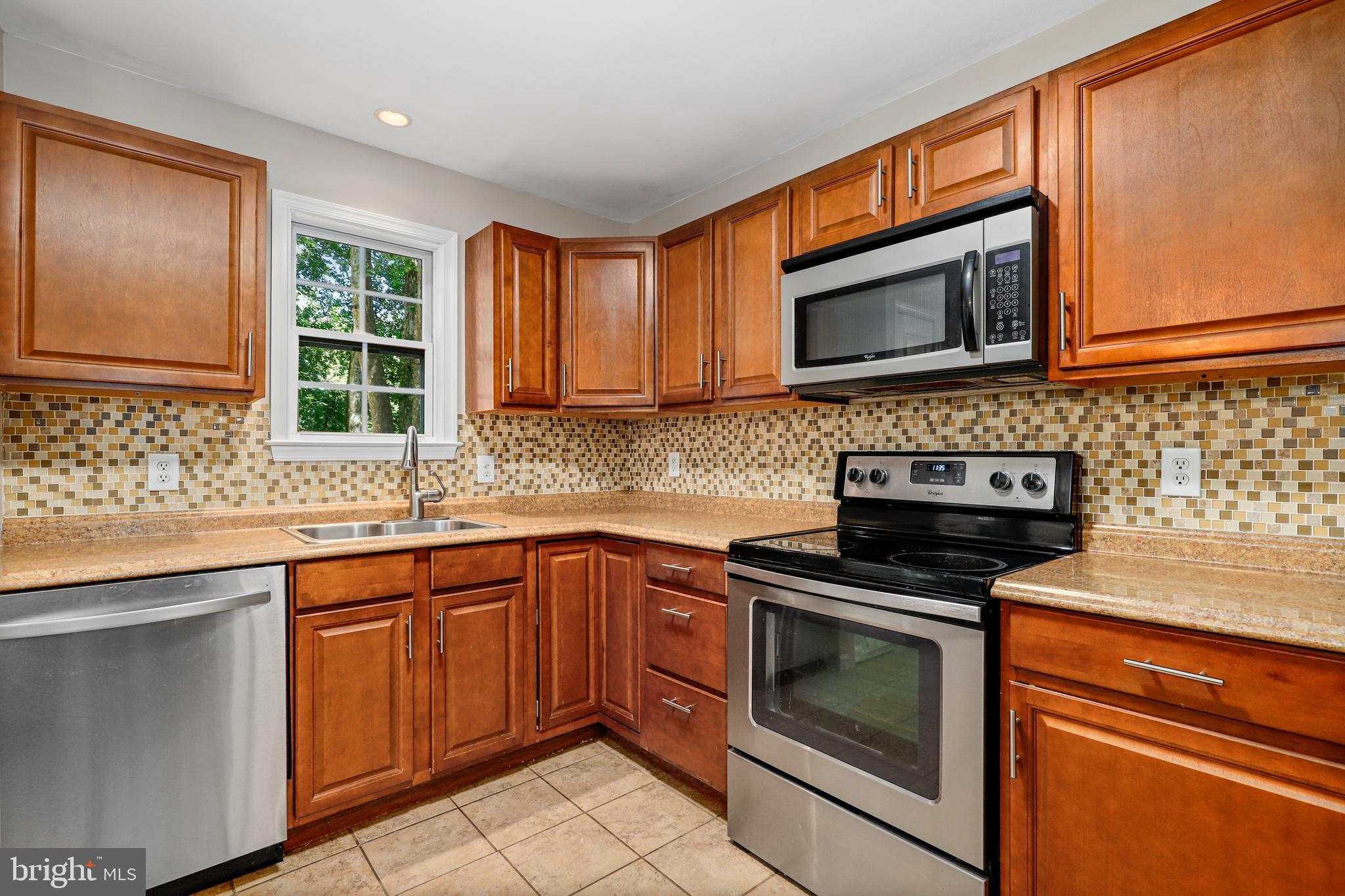 956 Wilson Road Huntingtown, MD 20639 - Photo 7 of 42 a kitchen with granite countertop a stove sink and microwave