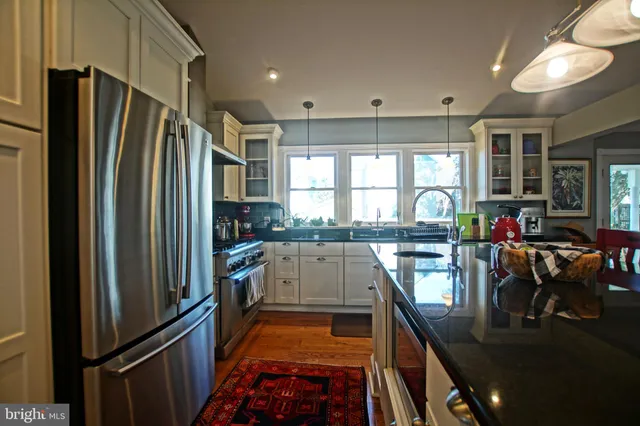 a kitchen with stainless steel appliances granite countertop a stove and a wooden floors