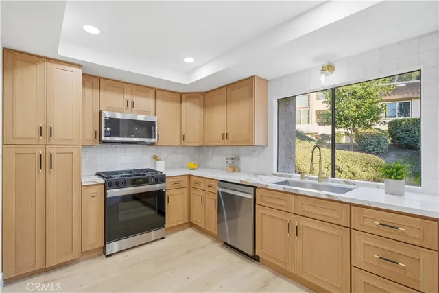 a kitchen with sink a microwave and cabinets