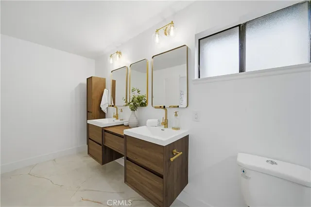 a bathroom with a sink a toilet and mirror