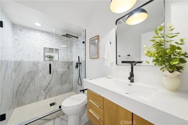 a bathroom with a sink a toilet and shower