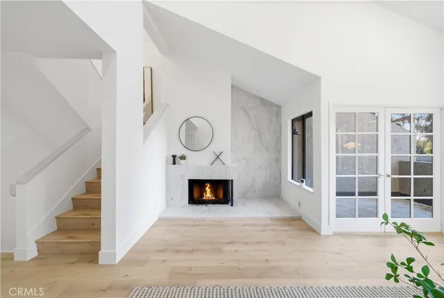 a view of a livingroom with wooden floor and a fireplace