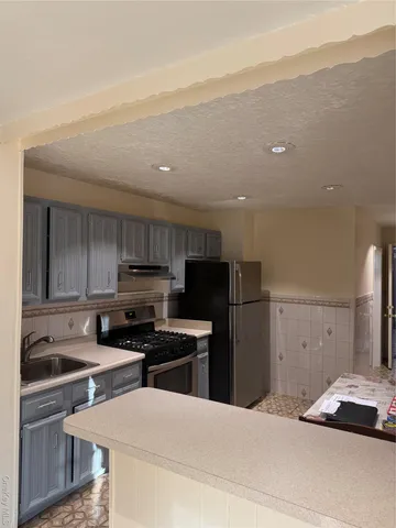 a kitchen with a sink a refrigerator and cabinets