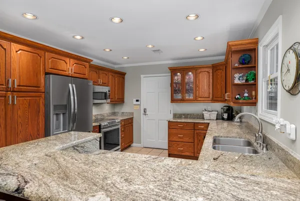 a kitchen with stainless steel appliances granite countertop a sink stove and refrigerator