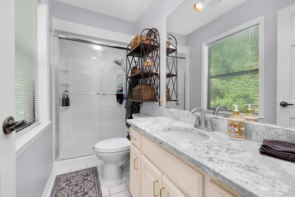 a bathroom with a toilet a sink a large mirror and shower