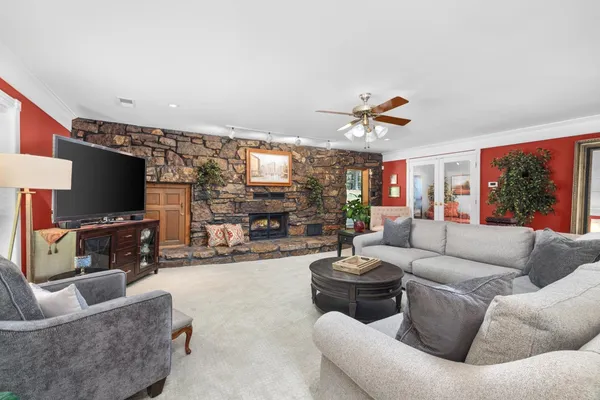 a living room with furniture a flat screen tv and a fireplace