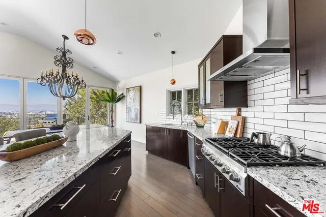 a kitchen with a stove and a wooden floor