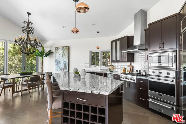 a kitchen with stainless steel appliances granite countertop a sink a stove and a refrigerator