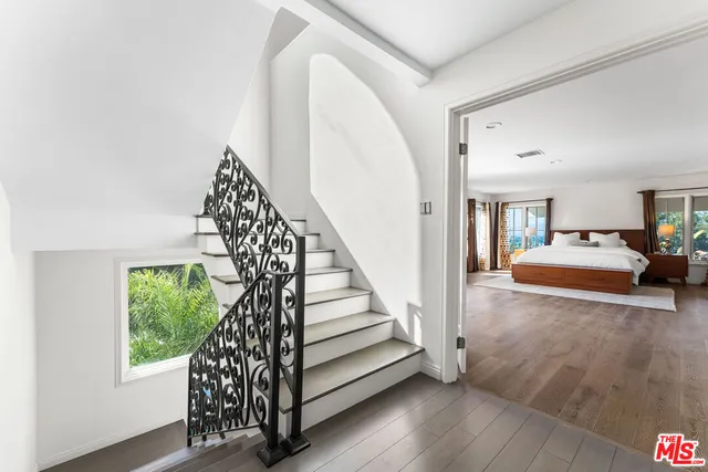 a bedroom with a large bed and a flat tv screen